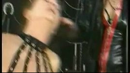 Masked dominitrax spanks one slave on her ass and squeezes cock of other dirty slave